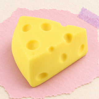 Squishy part de fromage mini doux – Squishy fromage triangle, mini ou effet farine (Mini triangle, plein), photo du produit sur papier pastel