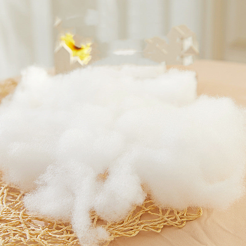 Losse vulwatten van polyester uit elkaar getrokken op een placemat