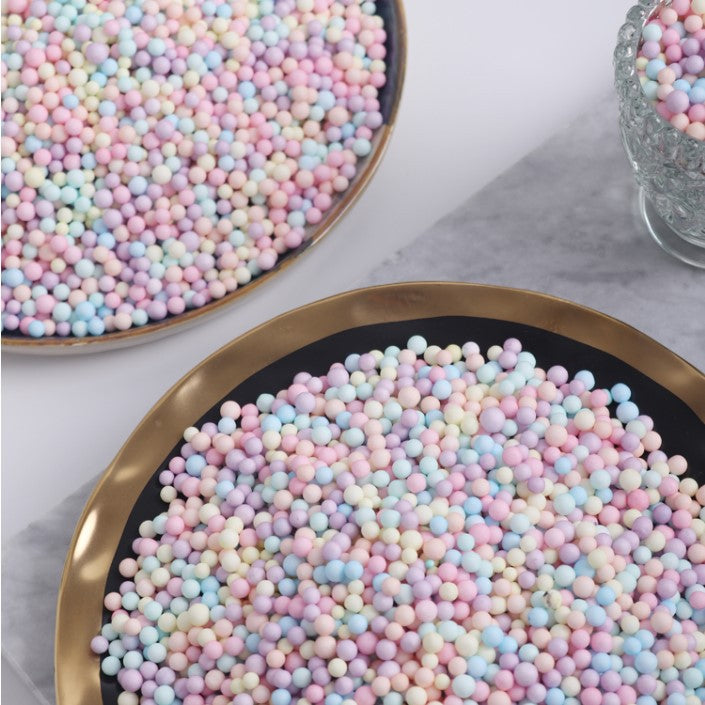 Two plates of foam beads in pastel colours