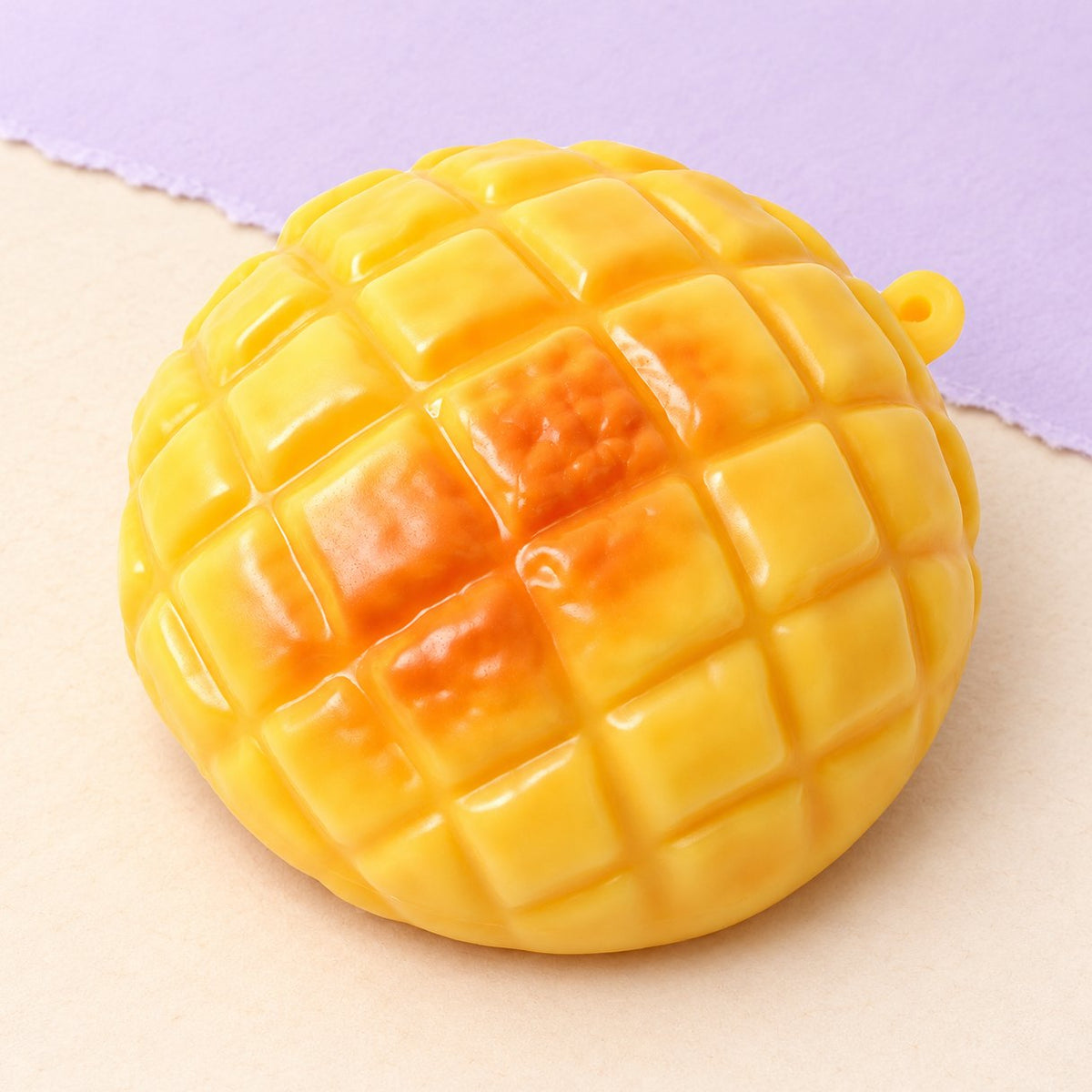 Ananasbrötchen Squishy, crunchy, 9 cm, Produktfoto auf Pastellpapier