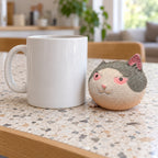 Angry cat squishy, next to a coffee mug for size comparison
