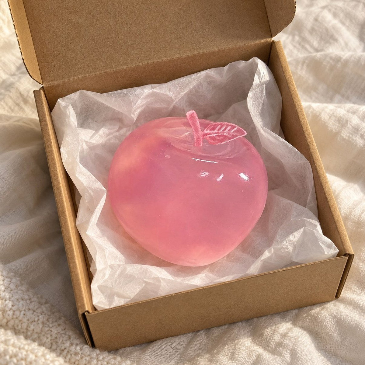 Poederroze appel squishy van maltose, net uit een pakketje met zijdepapier