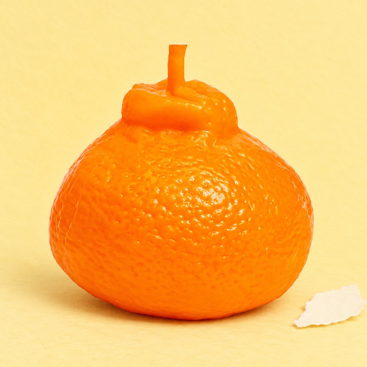 Appelsin-squishy, der ligner ægte frugt, produktfoto på pastelfarvet papir