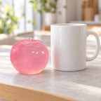 Squishy maçã maltose (Rosa pó), ao lado de uma caneca de café para comparar o tamanho