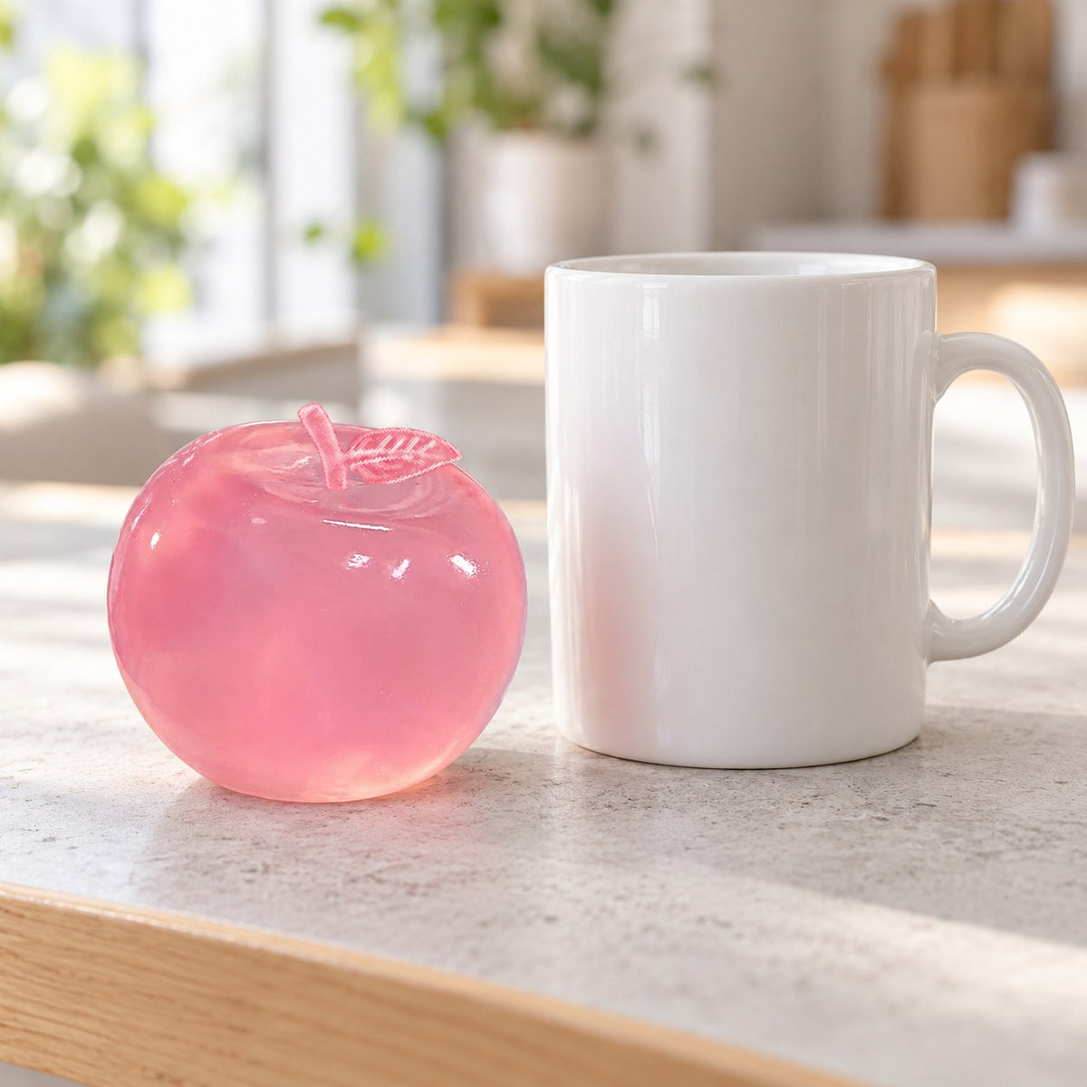 Squishy maçã maltose (Rosa pó), ao lado de uma caneca de café para comparar o tamanho