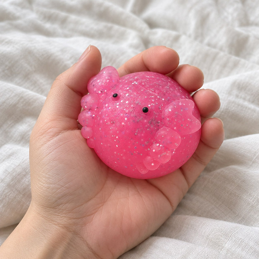 Axolotl squishy mochi glitter, held toward the camera, first-person view