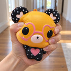 Bear Squishy with Heart Glasses, Slow Rising, 12 cm (Orange), being squeezed by hand, soft and squishy