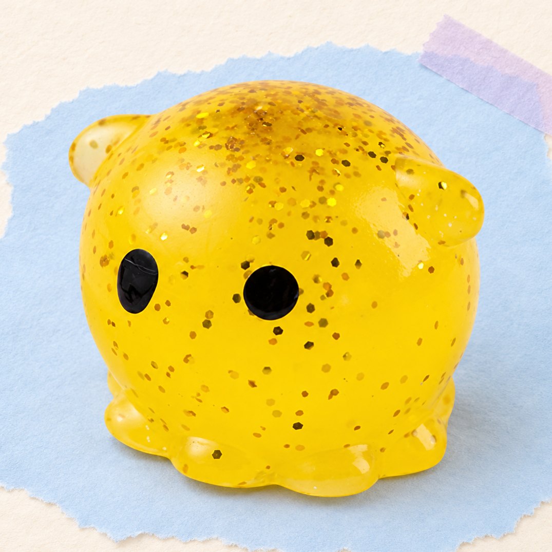 Blæksprutte-squishy med glimmer, produktfoto på pastelfarvet papir