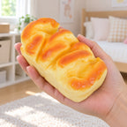 Bread Loaf Squishy, Brioche Style 11 or 15 cm (11 cm), held in a hand to show the real size
