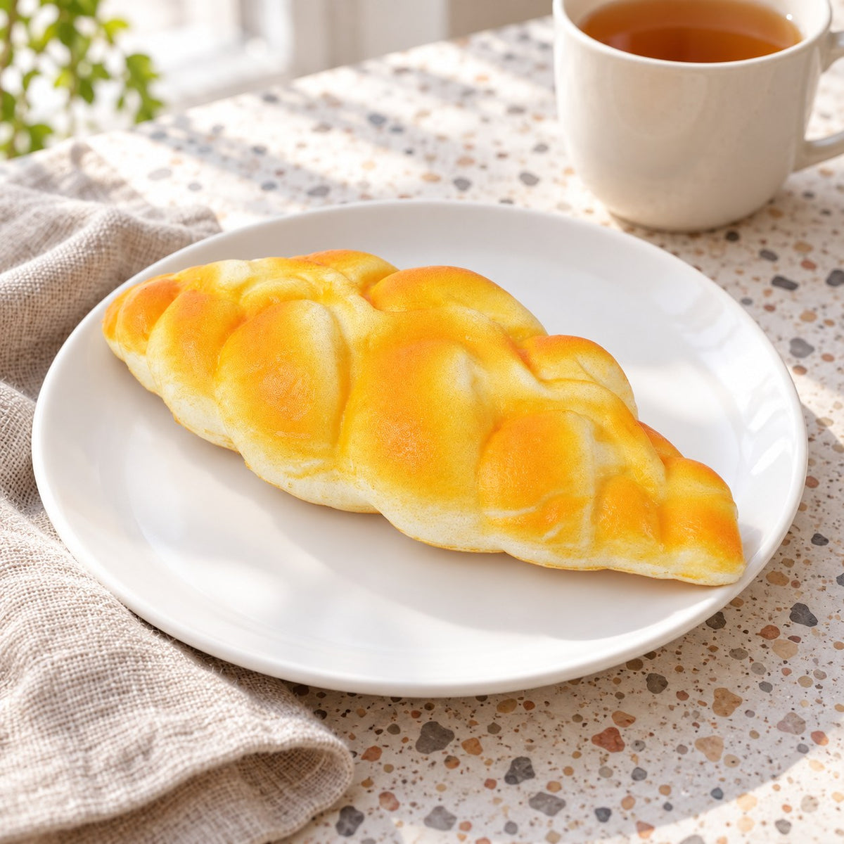 Braided bread squishy slow rising, on a plate on a breakfast table