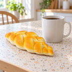 Braided bread squishy, next to a coffee mug for size comparison