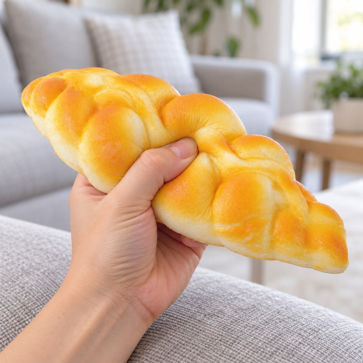 Braided bread squishy slow rising, being squeezed by hand, soft and squishy