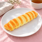Caterpillar bread squishy slow rising (21 cm), on a plate on a breakfast table