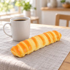 Caterpillar bread squishy (21 cm), next to a coffee mug for size comparison