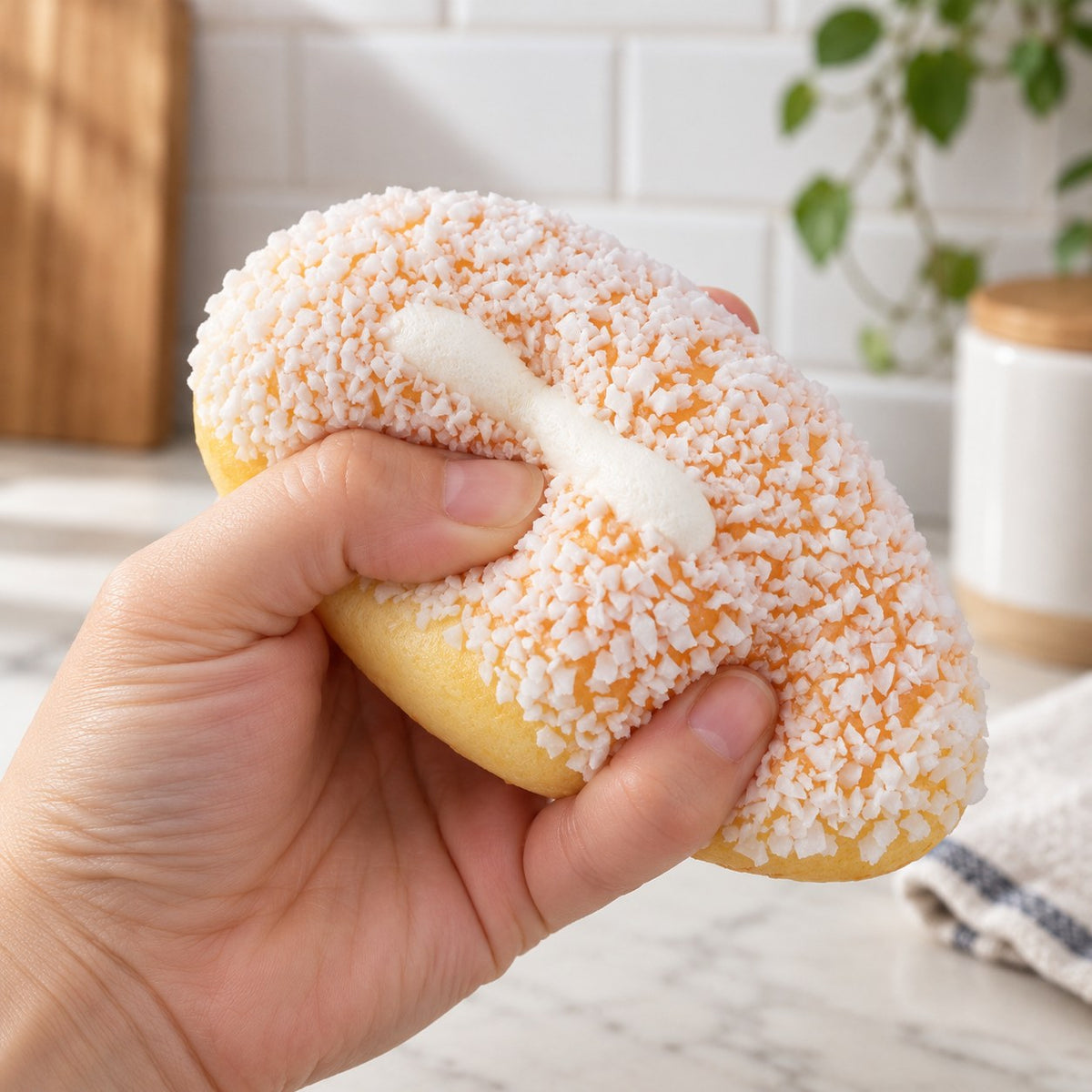 Coconut Cream Bun Squishy, 12 or 18 cm (12 cm), being squeezed by hand, soft and squishy