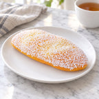 Coconut Cream Bun Squishy, 12 or 18 cm, on a plate on a breakfast table