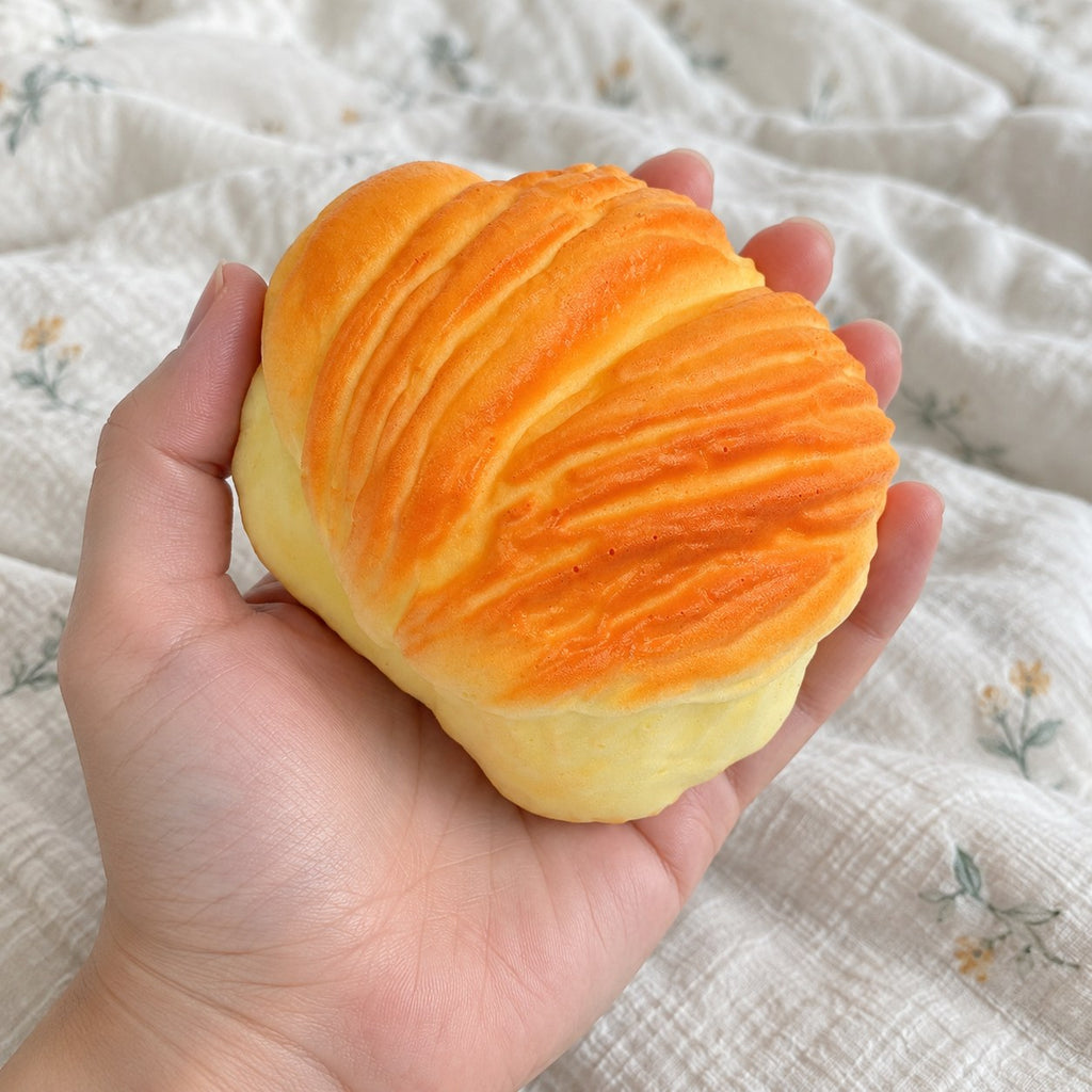Pastry squishy slow rising, held toward the camera, first-person view