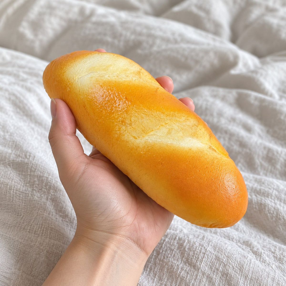 Dinner roll squishy slow rising, held toward the camera, first-person view