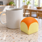 Toast squishy mini slow rising (6 cm), next to a coffee mug for size comparison