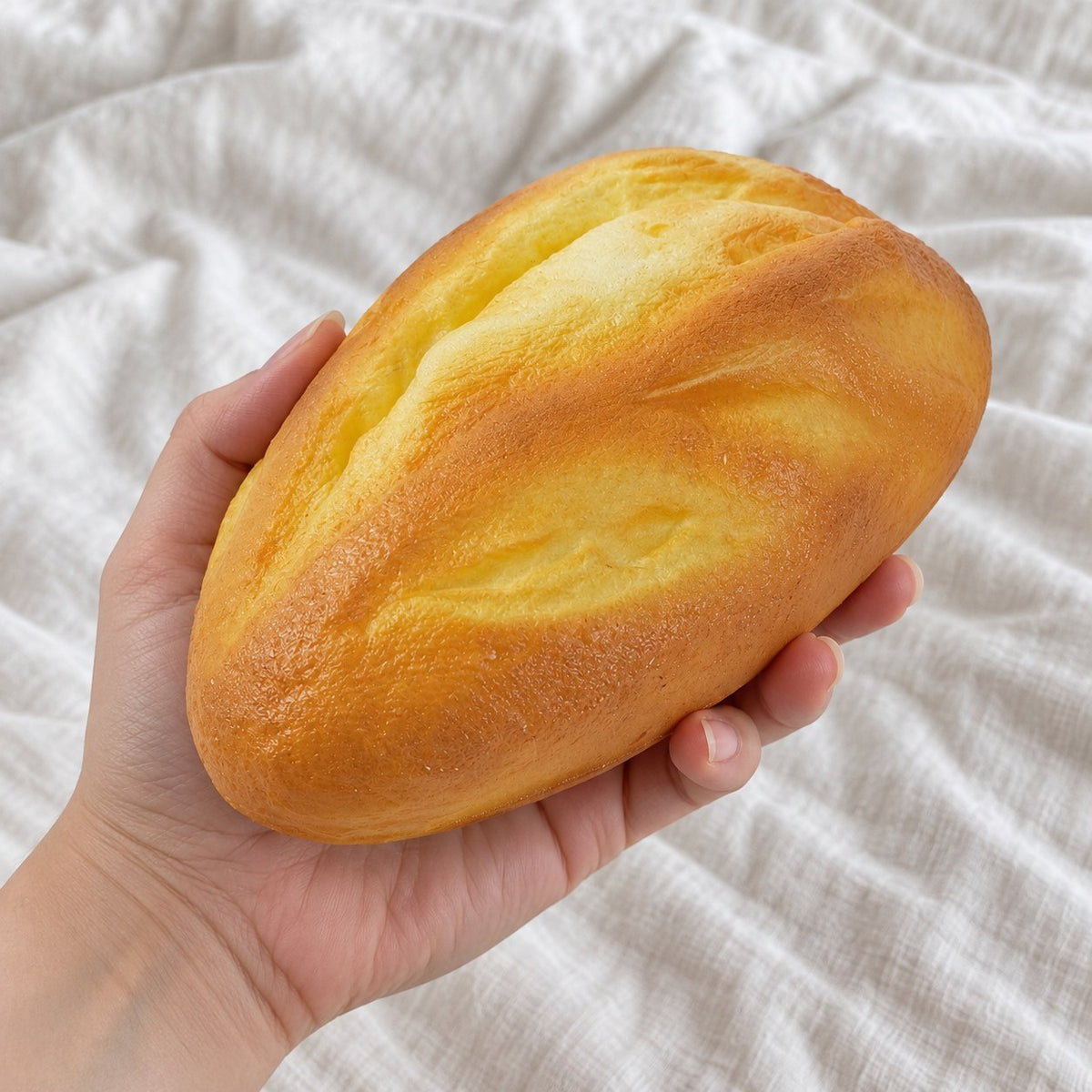 Bread loaf squishy soft, held toward the camera, first-person view