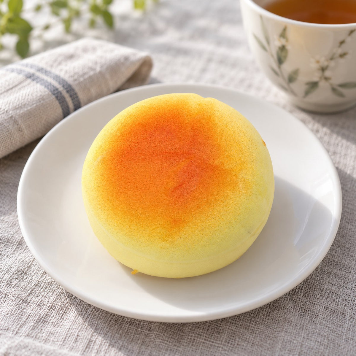 Round Bun Squishy, Small Bread Roll 6 cm, on a plate on a breakfast table