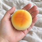 Round bun squishy, held toward the camera, first-person view