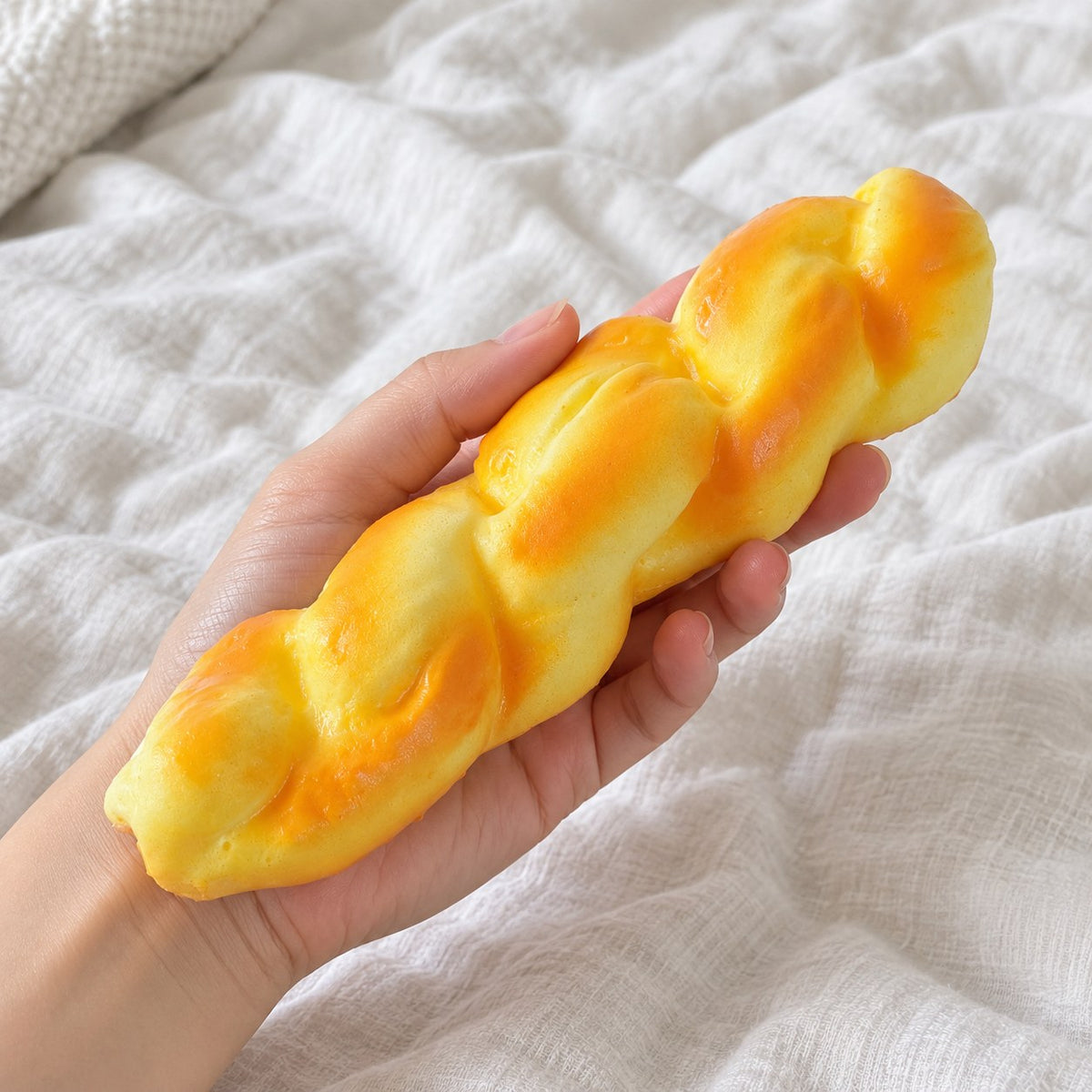 Twisted bread squishy, held toward the camera, first-person view