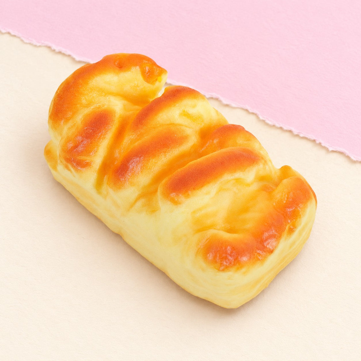 Squishy chleba brioška – Squishy chleba brioška, veka 11 nebo 15 cm (11 cm), fotografie produktu na pastelovém papíře