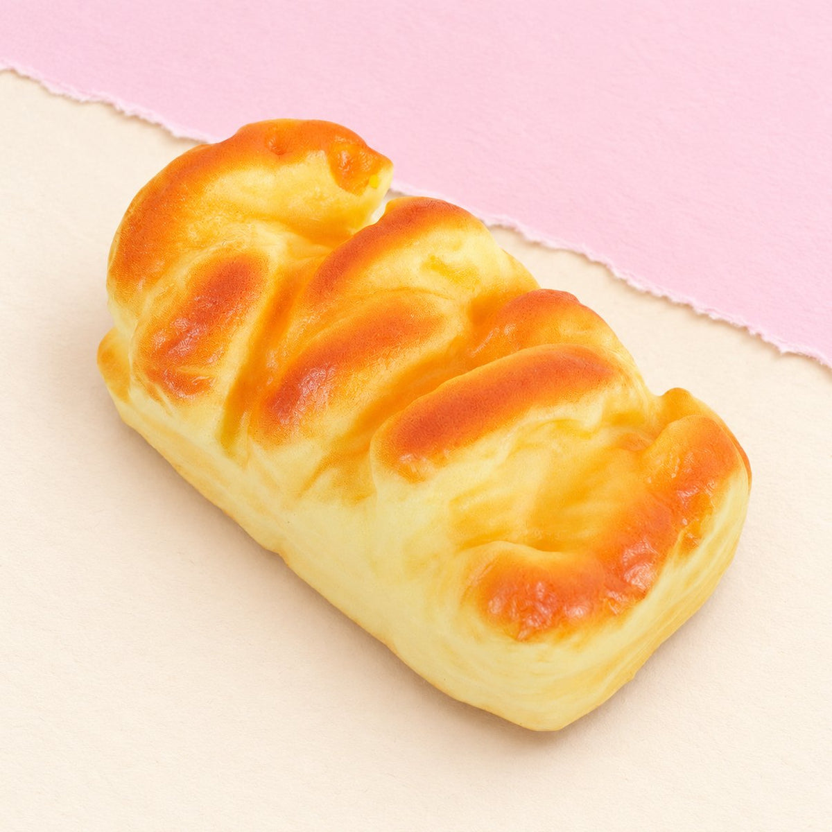 Brioche squishy als vormbrood van 11 cm op pastelkleurig papier