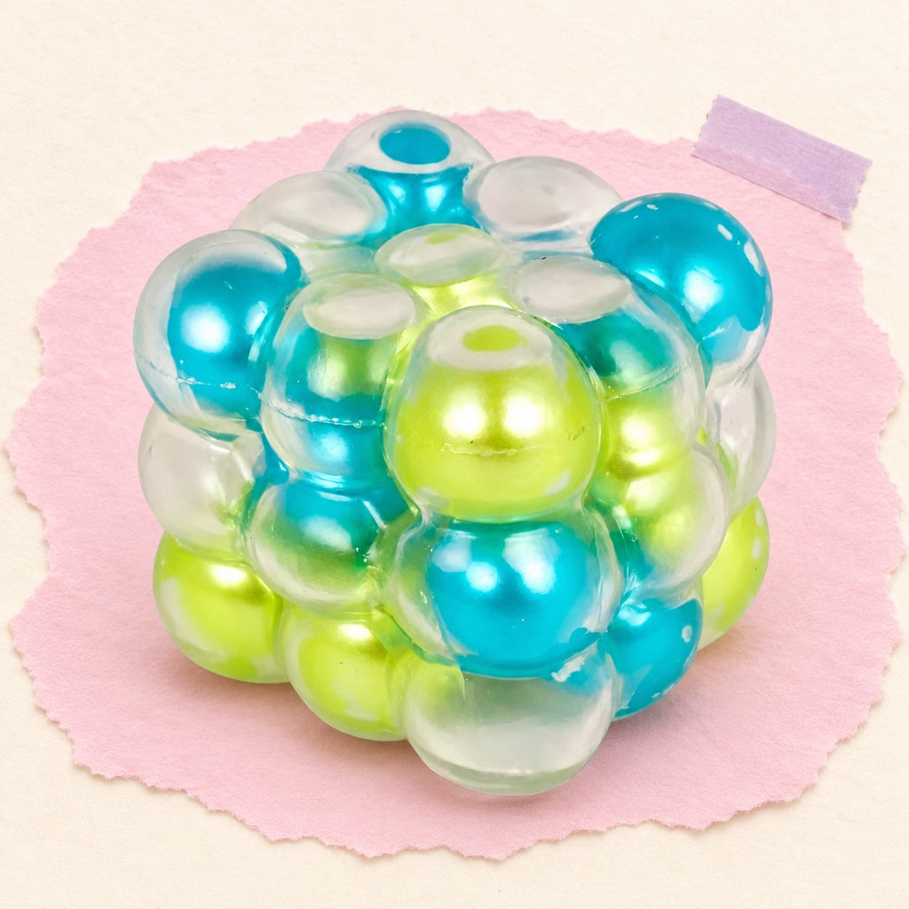 Bubble cube squishy jelly – Bubble Cube Squishy, Pearl Balls Inside, 6 cm (Blue-green mix), product photo on pastel paper