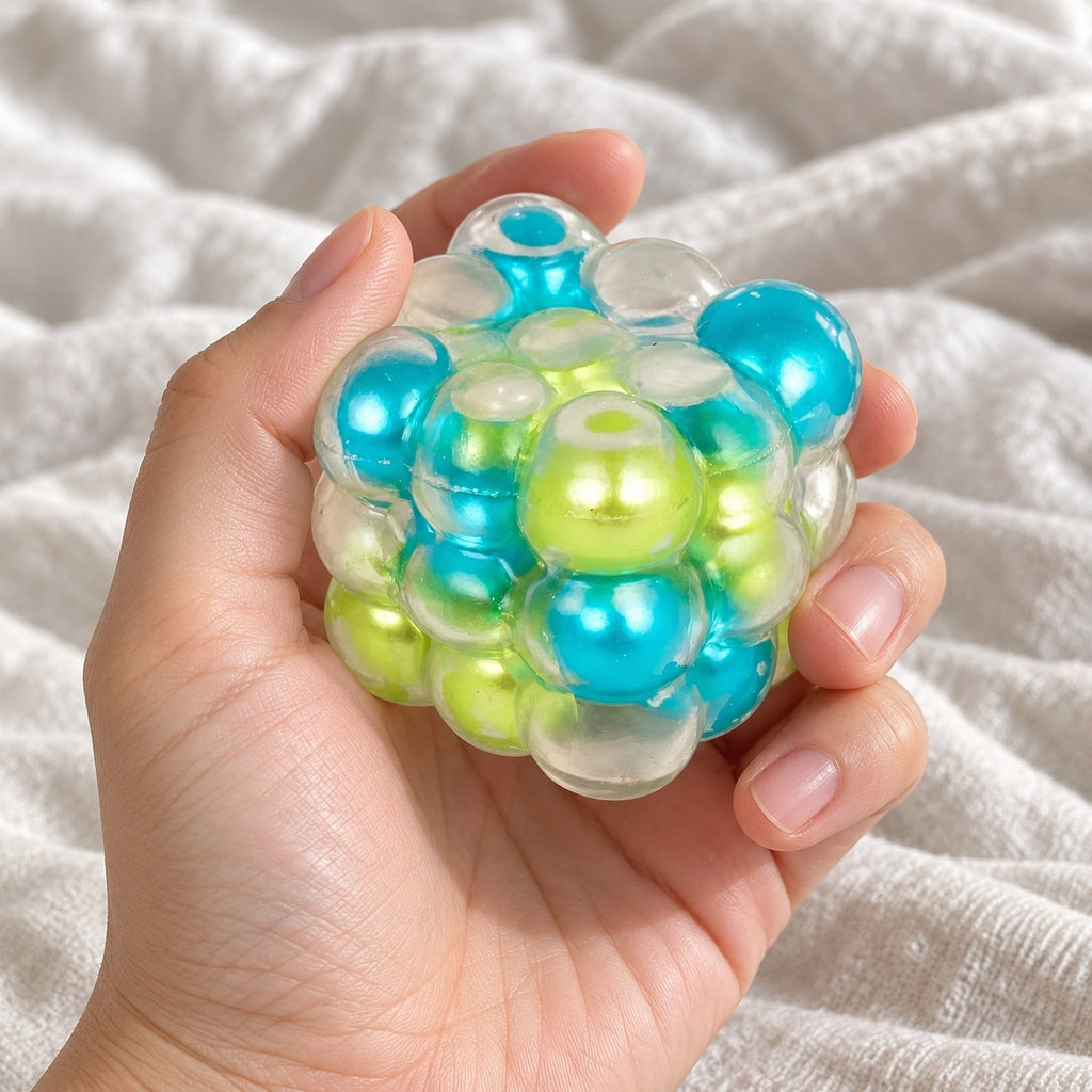 Bubble cube squishy (Blue-green mix), held toward the camera, first-person view