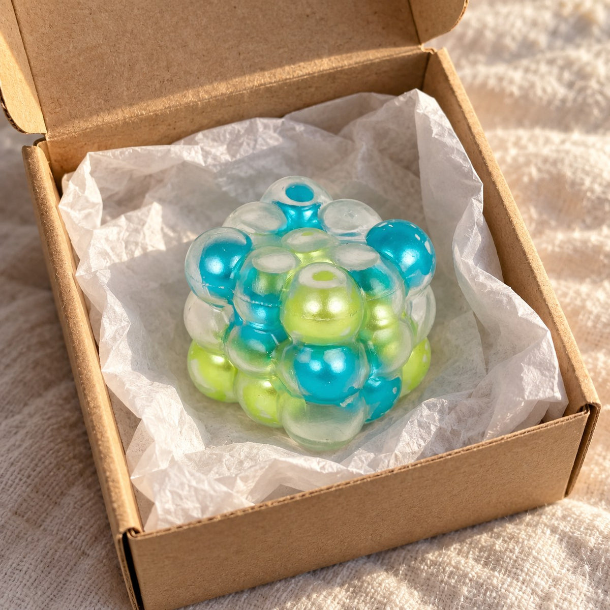 Bubble cube squishy (Blue-green mix), unboxed from a parcel with tissue paper