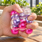 Bubble Cube Squishy, Pearl Balls Inside, 6 cm (Purple-red mix), being squeezed by hand, soft and squishy