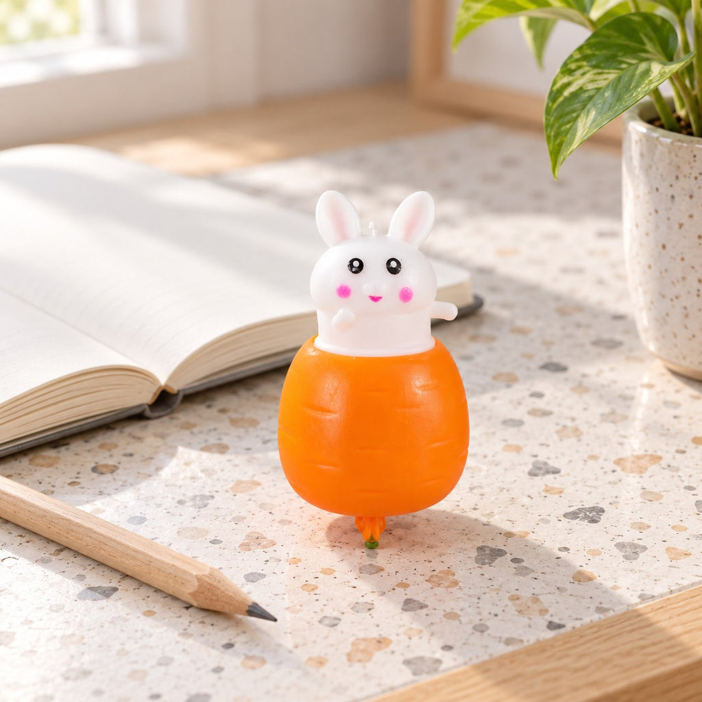 Bunny Pop-Up Squishy, Rabbit in a Carrot, on a desk with a notebook and pencil