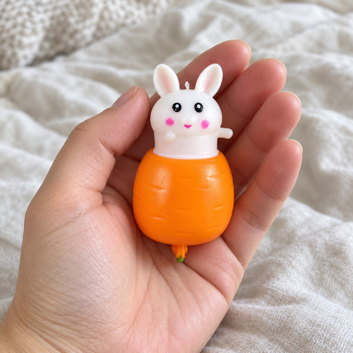Bunny squishy kawaii, held toward the camera, first-person view