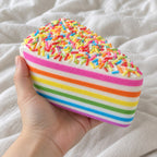 Jumbo Rainbow Cake Squishy, Layer Slice 15 cm (Rainbow sprinkles), held toward the camera, first-person view