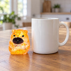 Capybara squishy stretchy (orange), next to a coffee mug for size comparison