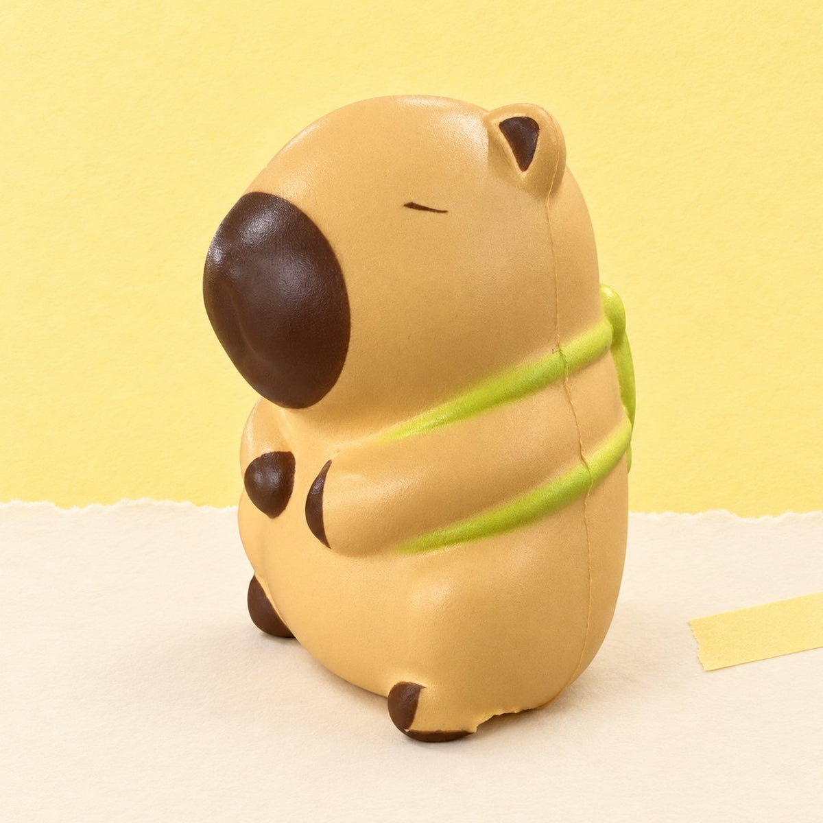 Capybara squishy met schildpad in lichtbeige, slow rising, op pastelkleurig papier