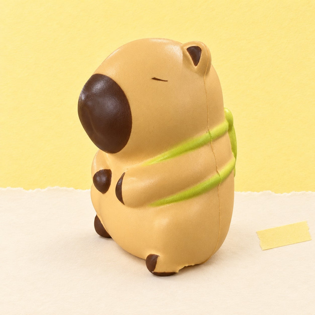 Capybara squishy slow rising – Capybara Squishy, Slow Rising with Turtle or Strawberry Hood (Turtle, light beige), product photo on pastel paper