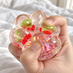 Cat paw squishy glitter jelly (Cherry red), being squeezed by hand, soft and squishy