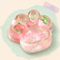 Cat paw squishy glitter jelly – Cat Paw Squishy with Fruit and Glitter, 7 cm (Strawberry pink), product photo on pastel paper