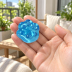 Mini Jelly Cat Paw Squishy, 4 cm (Blue), held in a hand to show the real size