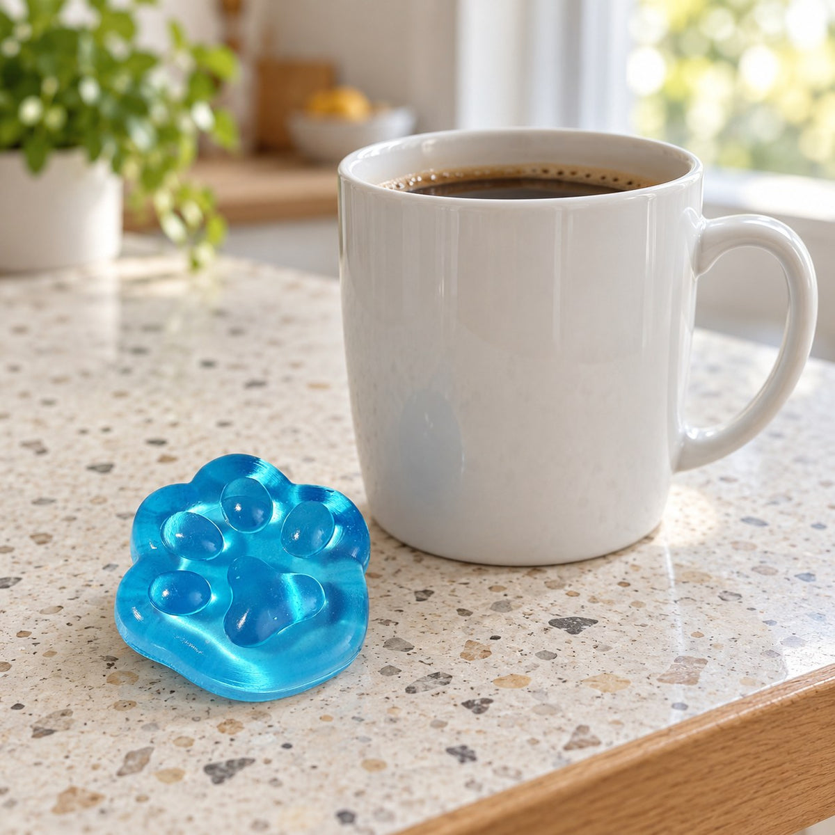 Mini Jelly Cat Paw Squishy, 4 cm (Blue), next to a coffee mug for size comparison