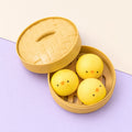 Chick squishy slow rising – Chick Bao Squishy, 3 Buns in Steamer Basket, product photo on pastel paper