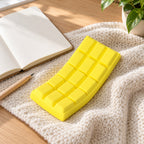 Chocolate Bar Squishy, Slow Rising 15.5 cm (Yellow), on a desk with a notebook and pencil