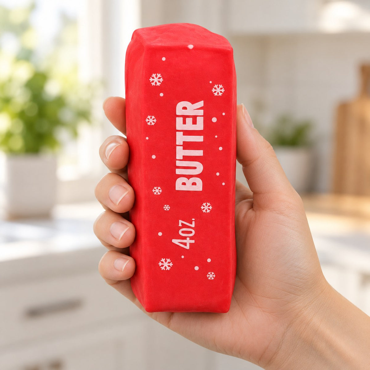 Christmas Butter Squishy, Crispy Stick in Gift Box (red), held in a hand to show the real size