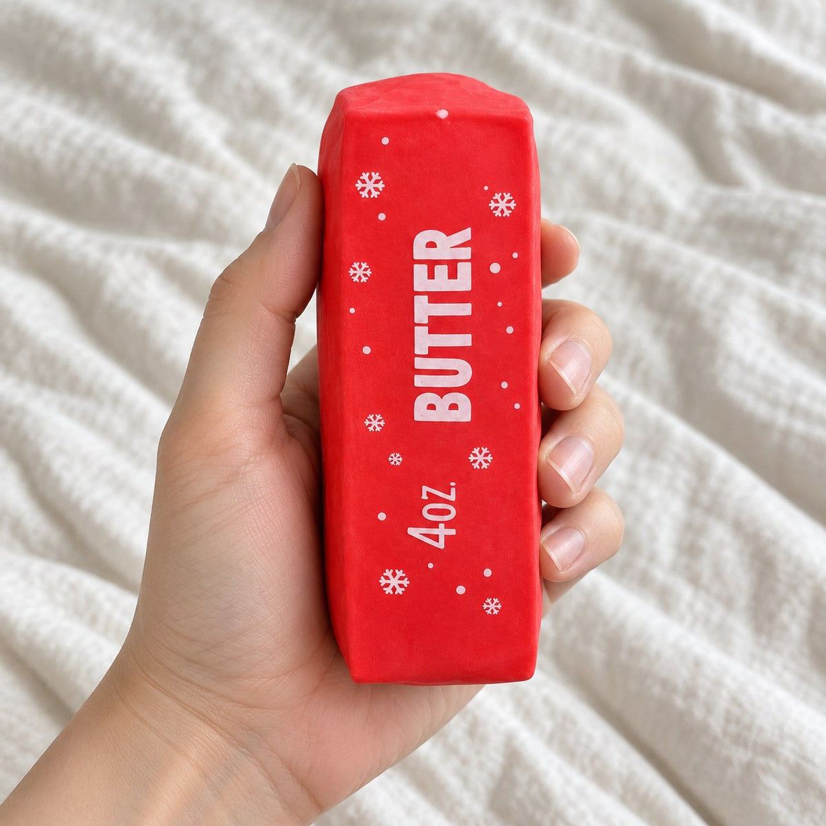 Christmas Butter Squishy, Crispy Stick in Gift Box (red), held toward the camera, first-person view