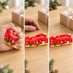 Christmas Butter Stick Squishy, Slow Rising (red), as a small gift next to a wrapped box