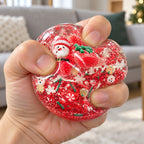 Christmas Coconut Oil Squishy Ball in Gift Box, 6.5 cm (Santa, red), being squeezed by hand, soft and squishy
