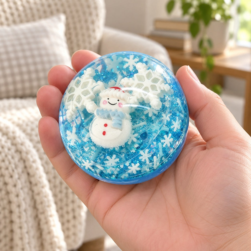 Christmas Coconut Oil Squishy Ball in Gift Box, 6.5 cm (Snowman, blue), held in a hand to show the real size
